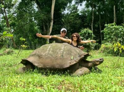 Reisende mit Riesenschildkröte auf Galápagos